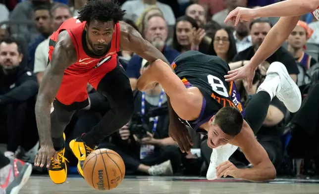 Houston Rockets forward Tari Eason, left, and Phoenix Suns guard Grayson Allen (8) dive after a loose ball during the first half of an NBA basketball game, Tuesday, April 7, 2026, in Phoenix. (AP Photo/Ross D. Franklin)