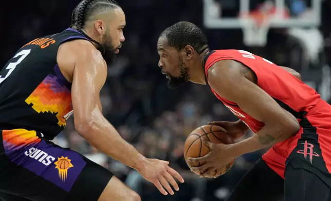 Houston Rockets forward Kevin Durant, right, pauses before dribbling against Phoenix Suns forward Dillon Brooks (3) during the first half of an NBA basketball game, Tuesday, April 7, 2026, in Phoenix. (AP Photo/Ross D. Franklin)