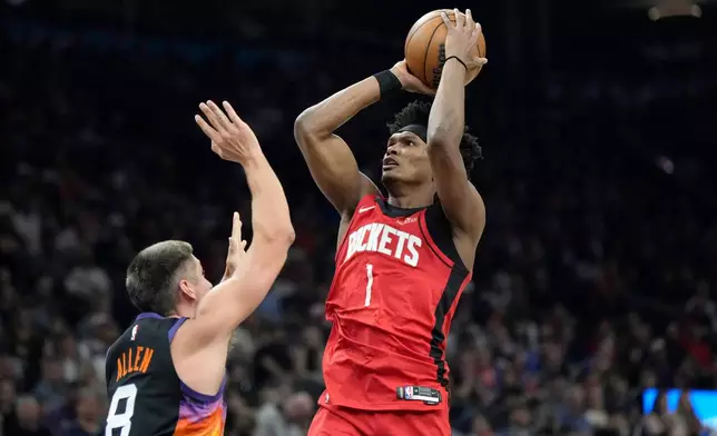 Houston Rockets guard Amen Thompson (1) shoots over Phoenix Suns guard Grayson Allen (8) during the first half of an NBA basketball game, Tuesday, April 7, 2026, in Phoenix. (AP Photo/Ross D. Franklin)