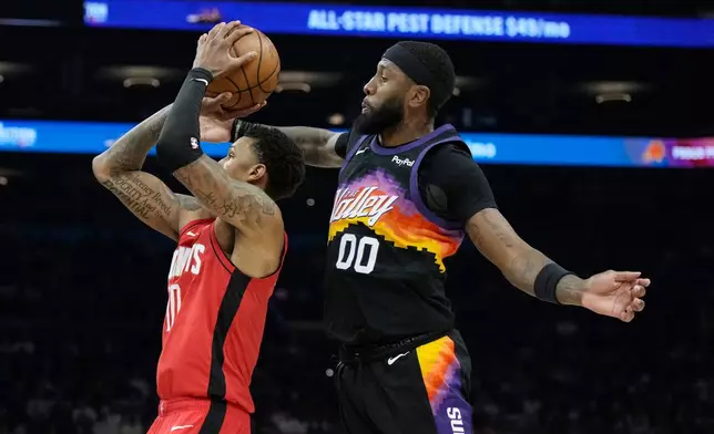 Phoenix Suns forward Royce O'Neale (00) goes in for a block against Houston Rockets forward Jabari Smith Jr., left, during the first half of an NBA basketball game, Tuesday, April 7, 2026, in Phoenix. (AP Photo/Ross D. Franklin)