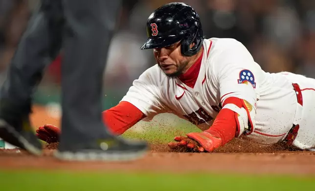 Boston Red Sox Willson Contreras dives back to first base after hitting a single in the fourth inning of a baseball game against the Milwaukee Brewers Tuesday, April 7, 2026, in Boston. (AP Photo/Robert F. Bukaty)