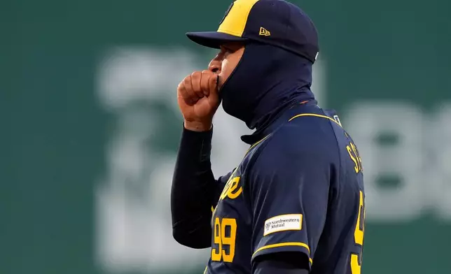 Milwaukee Brewers first baseman Gary Sánchez blows into his hand on a 43-degree F night during the third inning of a baseball game against the Boston Red Sox Tuesday, April 7, 2026, in Boston. (AP Photo/Robert F. Bukaty)
