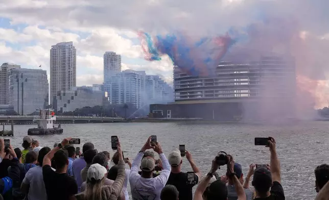 People watch pyrotechnics just before the controlled implosion of the former Mandarin Oriental Hotel on Brickell Key, Sunday, April 12, 2026, in Miami. (AP Photo/Rebecca Blackwell)