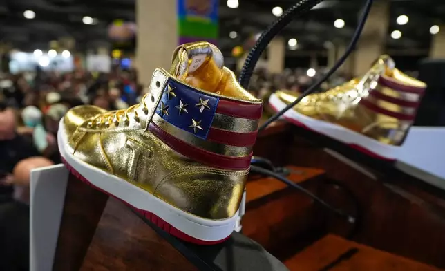 FILE - Gold Trump sneakers sit on the podium after Republican presidential candidate former President Donald Trump spoke at Sneaker Con Philadelphia, an event popular among sneaker collectors, and announces a gold Trump sneaker, in Philadelphia, Saturday, Feb. 17, 2024. (AP Photo/Manuel Balce Ceneta, File)
