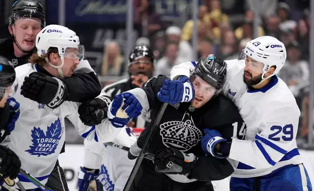 Los Angeles Kings center Samuel Helenius, left, and Toronto Maple Leafs defenseman Simon Benoit, second from left, scuffle as right wing Alex Laferriere, second from right, and center Bo Groulx also scuffle during the second period of an NHL hockey game Saturday, April 4, 2026, in Los Angeles. (AP Photo/Mark J. Terrill)