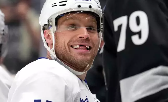 Toronto Maple Leafs center Max Domi, left, smiles as Los Angeles Kings center Samuel Helenius after they scuffled during the second period of an NHL hockey game Saturday, April 4, 2026, in Los Angeles. (AP Photo/Mark J. Terrill)