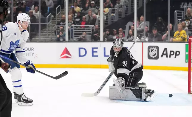 Toronto Maple Leafs center Steven Lorentz, left, scores on Los Angeles Kings goaltender Darcy Kuemper during the first period of an NHL hockey game Saturday, April 4, 2026, in Los Angeles. (AP Photo/Mark J. Terrill)
