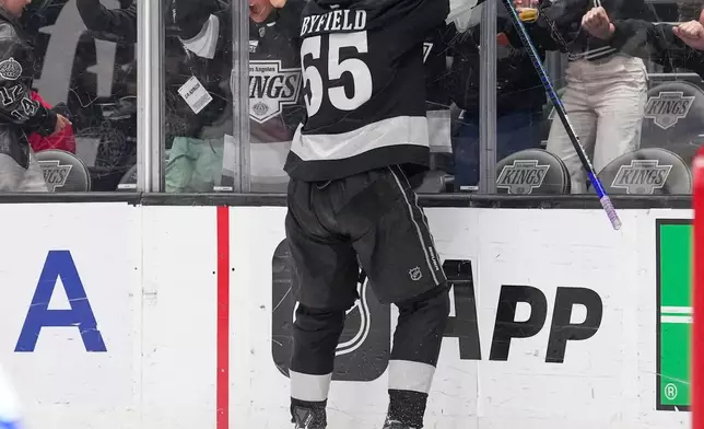 Los Angeles Kings right wing Quinton Byfield, top, celebrates after scoring the game-winning goal as Toronto Maple Leafs goaltender Joseph Woll lays on the ice during overtime of an NHL hockey game Saturday, April 4, 2026, in Los Angeles. (AP Photo/Mark J. Terrill)