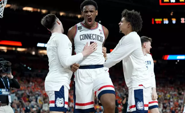 UConn forward Tarris Reed Jr., center, celebrates after the second half of an NCAA college basketball tournament semifinal game against Illinois at the Final Four, Saturday, April 4, 2026, in Indianapolis. (AP Photo/Abbie Parr)