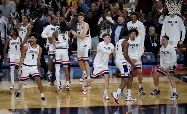UConn players celebrates their win after the second half of an NCAA college basketball tournament semifinal game against Illinois at the Final Four, Saturday, April 4, 2026, in Indianapolis. (AP Photo/AJ Mast)