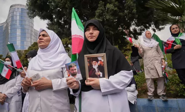 Medical workers attend a government-sponsored protest against the U.S.-Israeli military campaign outside Imam Khomeini Hospital in Tehran, Iran, Monday, April 6, 2026. (AP Photo/Francisco Seco)