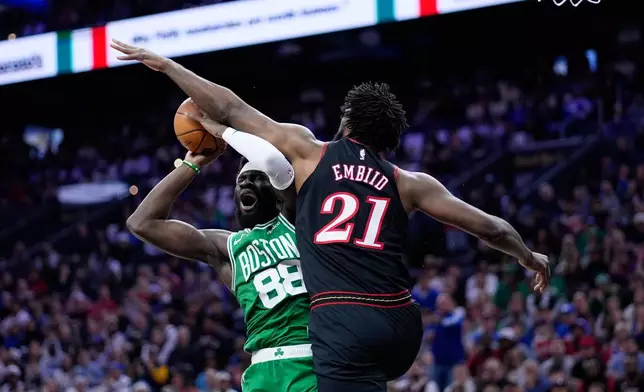 Boston Celtics' Neemias Queta, left, cannot get a shot past Philadelphia 76ers' Joel Embiid during the first half of Game 4 in a first-round NBA basketball playoffs series Sunday, April 26, 2026, in Philadelphia. (AP Photo/Matt Slocum)