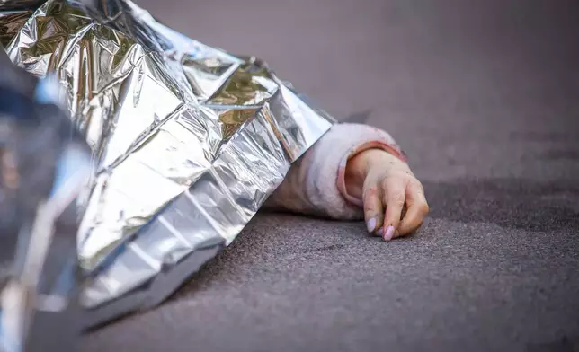 The body of victim is seen at the site where a gunman killed at least six people in the streets before being shot dead by police, in Kyiv, Ukraine, Saturday, April 18, 2026. (AP Photo/Dan Bashakov)