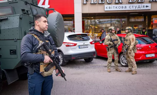 Police officers are seen at the site where a gunman killed at least six people in the streets before being shot dead by police, in Kyiv, Ukraine, Saturday, April 18, 2026. (AP Photo/Dan Bashakov)