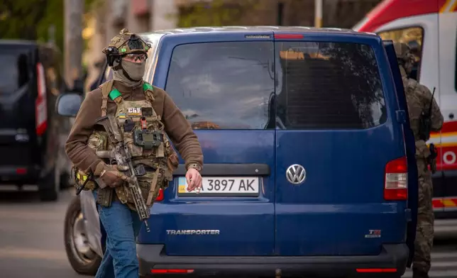 A police officer is seen at the site where a gunman killed at least six people in the streets before being shot dead by police, in Kyiv, Ukraine, Saturday, April 18, 2026. (AP Photo/Dan Bashakov)