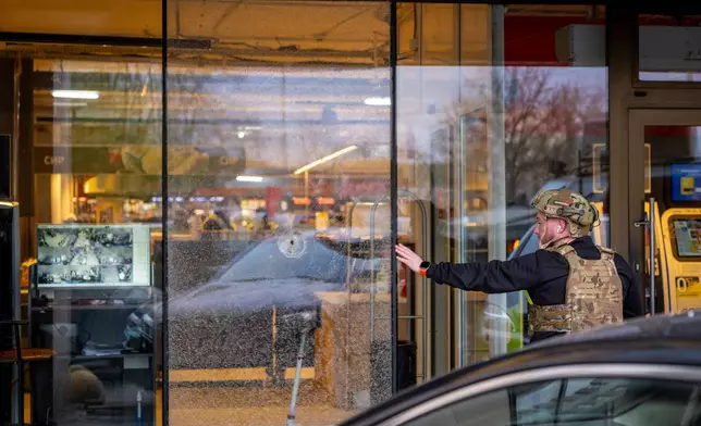 A police officer inspects the site where a gunman killed at least six people in the streets before being shot dead by police, in Kyiv, Ukraine, Saturday, April 18, 2026. (AP Photo/Dan Bashakov)