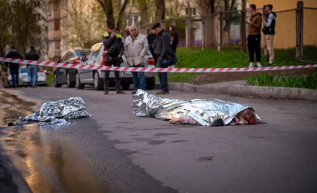 Bodies of victims are seen at the site where a gunman killed at least six people in the streets before being shot dead by police, in Kyiv, Ukraine, Saturday, April 18, 2026. (AP Photo/Dan Bashakov)
