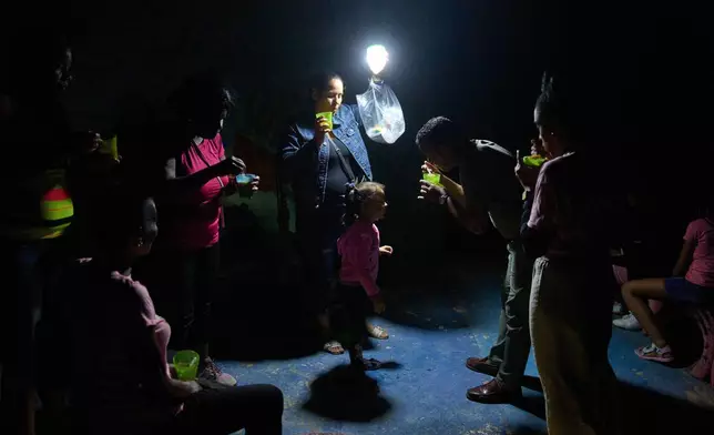 FILE - People eat cups of soup outside during a blackout in Havana, March 4, 2026. (AP Photo/Ramon Espinosa, File)
