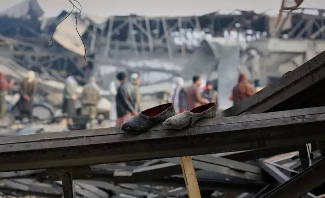 FILE - Residents and rescue workers inspect the site of an airstrike at a drug rehabilitation hospital in Kabul, Afghanistan, March 17, 2026. (AP Photo/Siddiqullah Alizai, File)