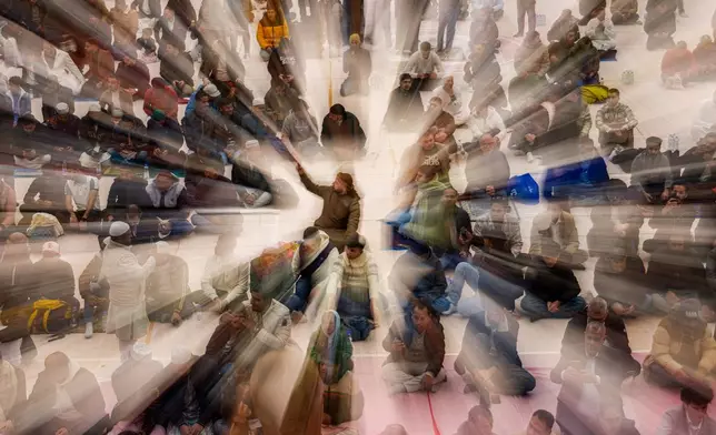 FILE - Muslims wait before Eid al-Fitr prayers in a sports hall in Bucharest, Romania, March 20, 2026. (AP Photo/Vadim Ghirda, File)