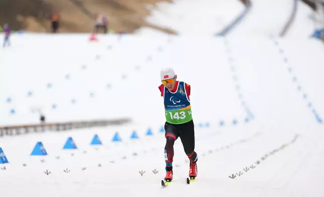 FILE- Wang Chenyang, of China, crosses the finish line in the cross-country skiing men's 10Km interval start classic standing final at the 2026 Winter Paralympics, in Tesero, Italy, March 11, 2026. (AP Photo/Evgeniy Maloletka, File)