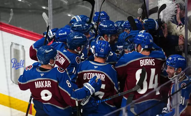 Colorado Avalanche center Nicolas Roy (10) is congratulated by teammates after scoring the game winning goal against the Los Angeles Kings in overtime of Game 2 in the first round of the NHL hockey Stanley Cup playoffs, Tuesday, April 21, 2026, in Denver. (AP Photo/Jack Dempsey)