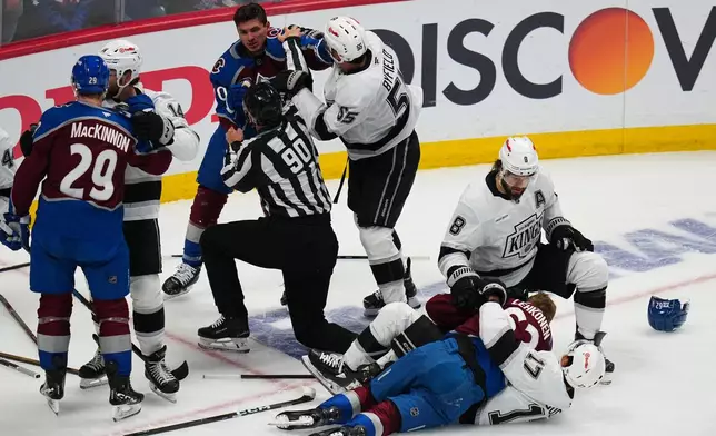 Linesman Travis Toomey (90) tries to break up a fight between Colorado Avalanche defenseman Sam Malinski (70) and Los Angeles Kings right wing Quinton Byfield (55) during the first period of Game 2 in the first round of the NHL hockey Stanley Cup playoffs, Tuesday, April 21, 2026, in Denver. (AP Photo/Jack Dempsey)