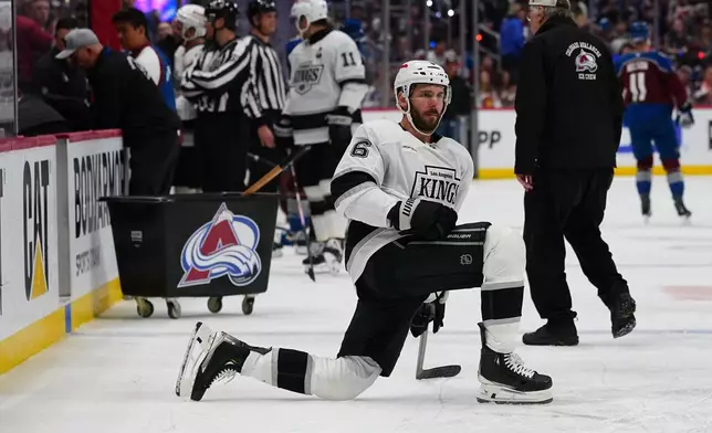 Los Angeles Kings defenseman Joel Edmundson stretches while waiting for a broken piece of glass to be replaced on the team's bench during the second period of Game 2 in the first round of the NHL hockey Stanley Cup playoffs against the Colorado Avalanche, Tuesday, April 21, 2026, in Denver. (AP Photo/Jack Dempsey)