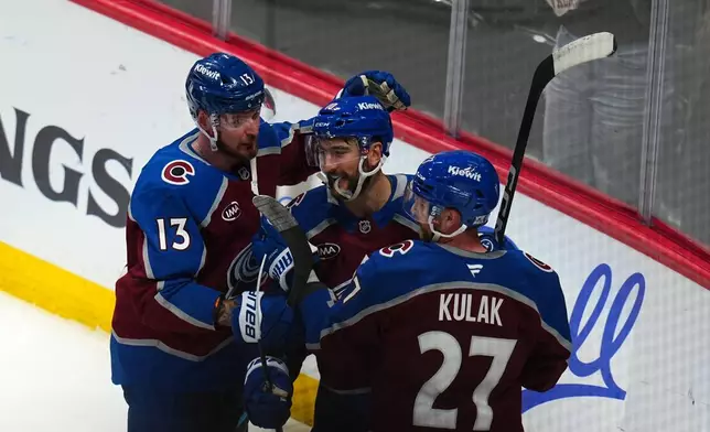Colorado Avalanche center Nicolas Roy (10) is congratulated by teammates Valeri Nichushkin (13) and Brett Kulak (27) after scoring the game winning goal against the Los Angeles Kings in overtime of Game 2 in the first round of the NHL hockey Stanley Cup playoffs, Tuesday, April 21, 2026, in Denver. (AP Photo/Jack Dempsey)