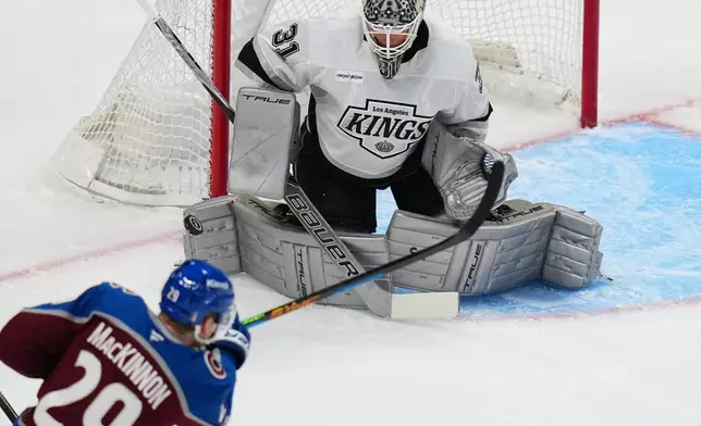 Los Angeles Kings goaltender Anton Forsberg (31) blocks a shot by Colorado Avalanche center Nathan MacKinnon (29) during the first period of Game 2 in the first round of the NHL hockey Stanley Cup playoffs, Tuesday, April 21, 2026, in Denver. (AP Photo/Jack Dempsey)