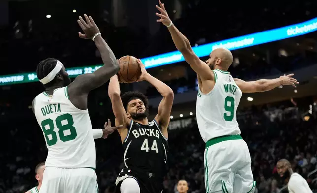 Milwaukee Bucks' Andre Jackson Jr. (44) drives to the basket between Boston Celtics' Neemias Queta (88) and Derrick White (9) during the first half of an NBA basketball game Friday, April 3, 2026, in Milwaukee. (AP Photo/Aaron Gash)
