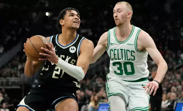 Milwaukee Bucks' Ousmane Dieng, left, drives to the basket against Boston Celtics' Sam Hauser (30) during the first half of an NBA basketball game Friday, April 3, 2026, in Milwaukee. (AP Photo/Aaron Gash)