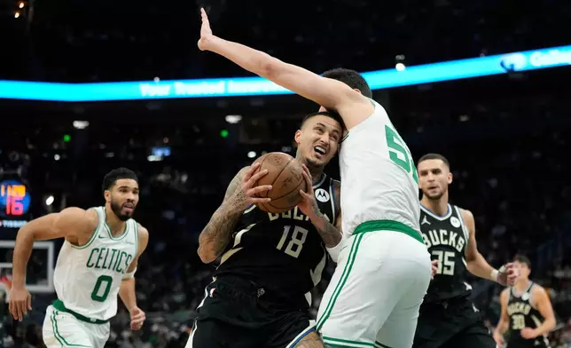 Milwaukee Bucks' Kyle Kuzma (18) drives to the basket against Boston Celtics' Luka Garza, center right, during the first half of an NBA basketball game Friday, April 3, 2026, in Milwaukee. (AP Photo/Aaron Gash)