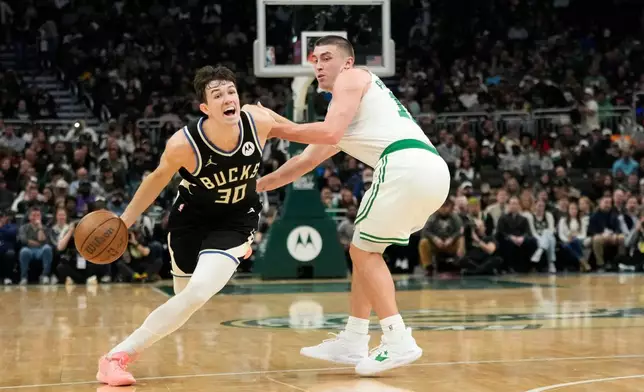 Milwaukee Bucks' Cormac Ryan (30) drives to the basket against Boston Celtics' Payton Pritchard, right, during the first half of an NBA basketball game Friday, April 3, 2026, in Milwaukee. (AP Photo/Aaron Gash)