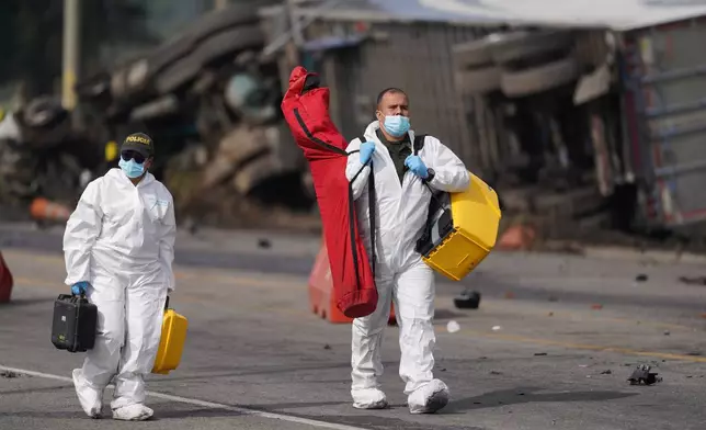 Forensics respond to a fatal, multiple vehicle accident in Cogua, Colombia, Wednesday, April 1, 2026. (AP Photo/Ivan Valencia)