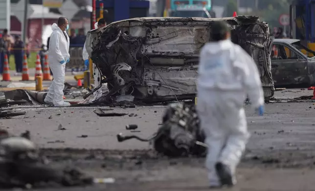 Forensics work at the scene of a fatal, multiple vehicle accident in Cogua, Colombia, Wednesday, April 1, 2026. (AP Photo/Ivan Valencia)