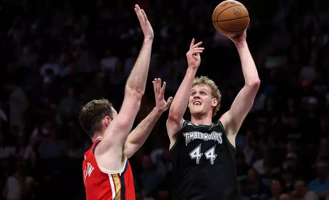 Minnesota Timberwolves center Rocco Zikarsky, right, shoots over New Orleans Pelicans center Hunter Dickinson (4) during the first half of an NBA basketball game Sunday, April 12, 2026, in Minneapolis. (AP Photo/Matt Krohn)