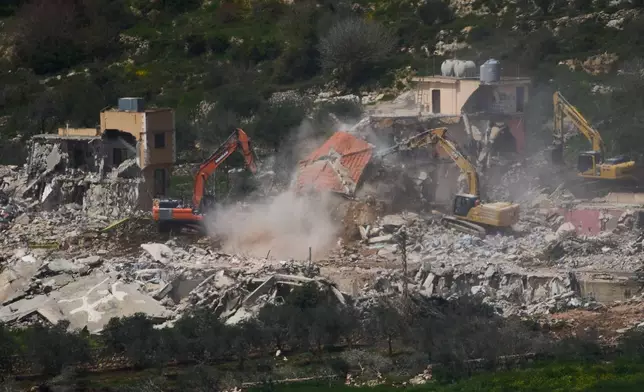 Israeli bulldozers demolish homes in southern Lebanon, as seen from northern Israel, Sunday, April 12, 2026. (AP Photo/Ariel Schalit)