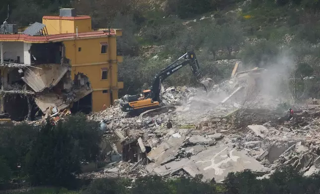 Israeli bulldozers demolish homes in southern Lebanon, as seen from northern Israel, Sunday, April 12, 2026. (AP Photo/Ariel Schalit)