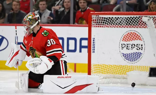 Chicago Blackhawks goalie Spencer Knight (30) misses a goal by Carolina Hurricanes' Sean Walker during the first period of an NHL hockey game in Chicago, Thursday, April 9, 2026. (AP Photo/Paul Beaty)