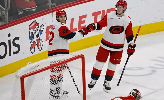 Carolina Hurricanes' Logan Stankoven (22) celebrates with teammate Jackson Blake (53) after scoring a goal during the second period of an NHL hockey game against the Chicago Blackhawks in Chicago, Thursday, April 9, 2026. (AP Photo/Paul Beaty)