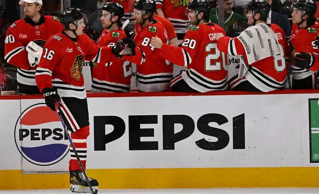 Chicago Blackhawks' Anton Frondell (16) celebrates with teammates at the bench after scoring a goal during the first period of an NHL hockey game against the Carolina Hurricanes in Chicago, Thursday, April 9, 2026. (AP Photo/Paul Beaty)