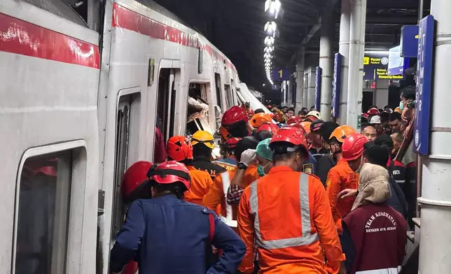 Rescuers search for victims after a train collision at a station in Bekasi, Indonesia, Monday, April 27, 2026. (AP Photo/Achmad Ibrahim)