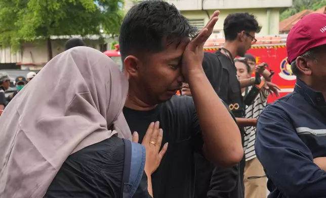 A relative of a victim of a train collision weeps in Bekasi, Indonesia, Tuesday, April 28, 2026. (AP Photo/Tatan Syuflana)