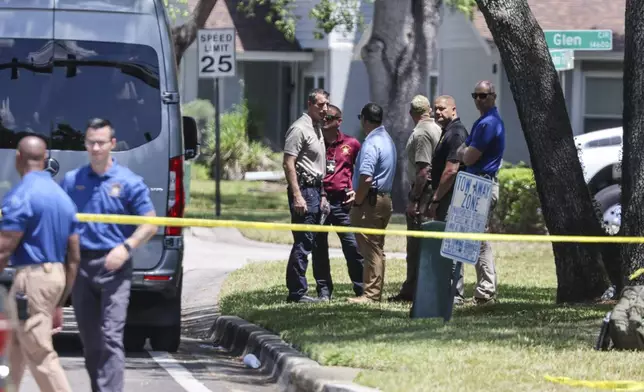Detectives with the Hillsborough County Sheriff's Office join an investigation inside the Lake Forest subdivision of Tampa, Fla., on Friday, April 24, 2026, where authorities said a man was taken into custody after barricading himself inside a home, in connection to the search for two missing University of South Florida graduate students. (Douglas R. Clifford/Tampa Bay Times via AP)