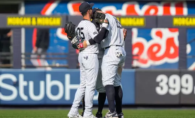 New York Yankees outfielders Cody Bellinger (35), Trent Grisham (12) and Aaron Judge (99) embrace each other after wining a home-opener baseball game against the Miami Marlins, Friday, April 3, 2026, in New York. (AP Photo/Yuki Iwamura)