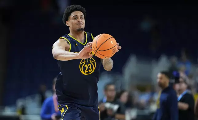 Michigan's Yaxel Lendeborg passes during practice ahead of an NCAA college basketball tournament semifinal game against Arizona at the Final Four, Friday, April 3, 2026, in Indianapolis. (AP Photo/Michael Conroy)
