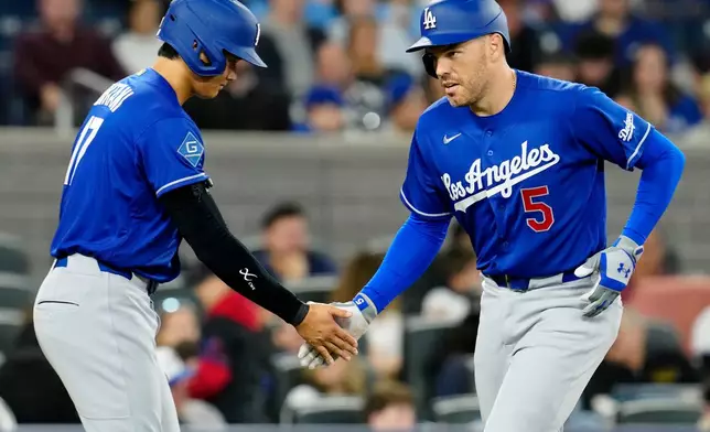 Los Angeles Dodgers' Shohei Ohtani (17) congratulates teammate Freddie Freeman (5) who comes in to score on his two-run home run against the Toronto Blue Jays during third-inning baseball game action in Toronto, Monday, April 6, 2026. (Frank Gunn/The Canadian Press via AP)