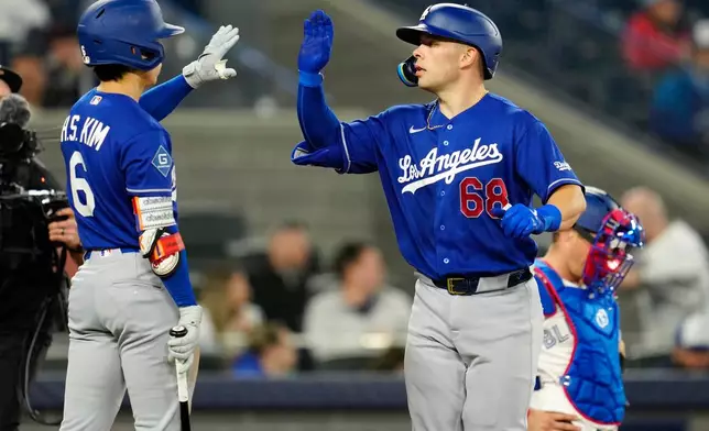 Los Angeles Dodgers' Dalton Rushing (68) celebrates afte his second home run of the night with teammate Hyeseong Kim (6) during eighth-inning baseball game action against the Toronto Blue Jays in Toronto, Monday, April 6, 2026. (Frank Gunn/The Canadian Press via AP)
