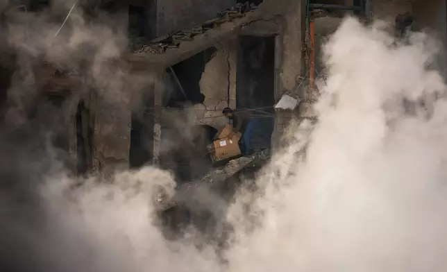 A man gathers his belongings from his home, which has been destroyed in an Israeli airstrike a day earlier in Beirut, Lebanon, Thursday, April 9, 2026. (AP Photo/Emilio Morenatti)